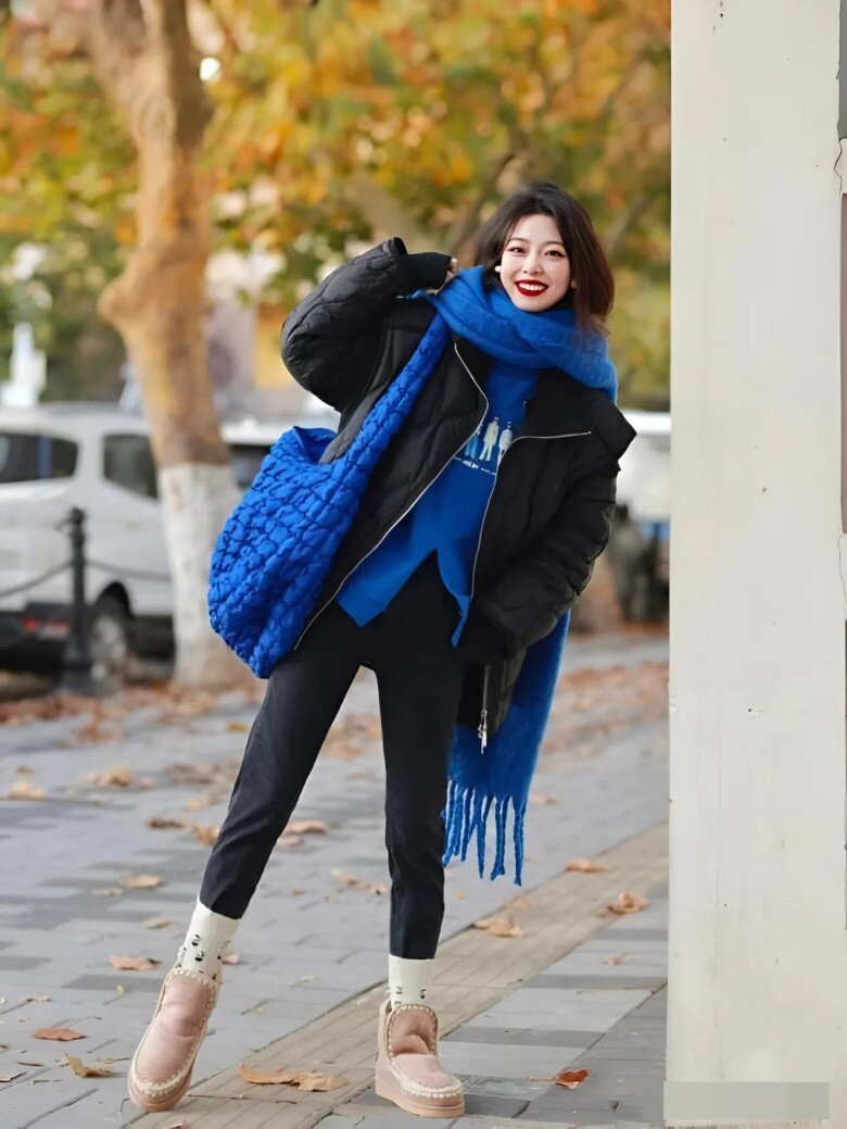 Áo phao đen phối với áo màu xanh cổ điển trông thời trang và nổi bật.